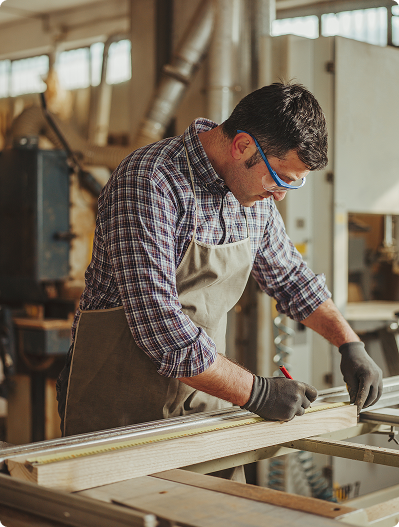 Man measuring timber in workshop