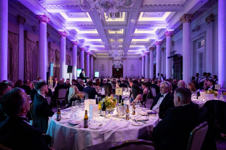 Banquet dinner setup with uplighting in grand hall