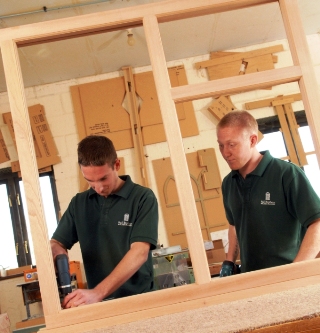 Two young apprentices working on timber framing