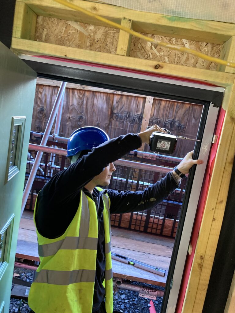 Man using a power tool on a timber window frame