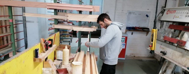 Worker aligning parts of a wooden frame
