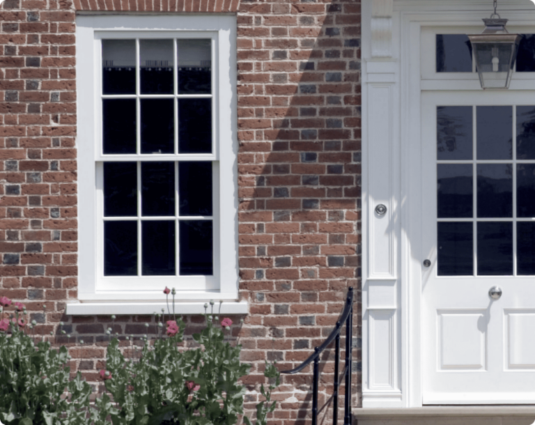 White door and sash window on red brick house