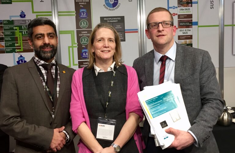 Three people smiling in group photo at expo