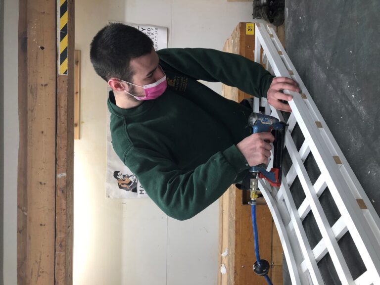 Young male apprentice using a mitre saw