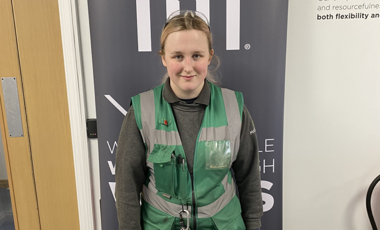 Smiling female apprentice in uniform