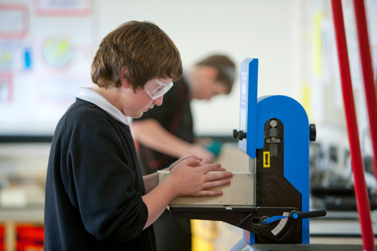 Student using bandsaw in a workshop