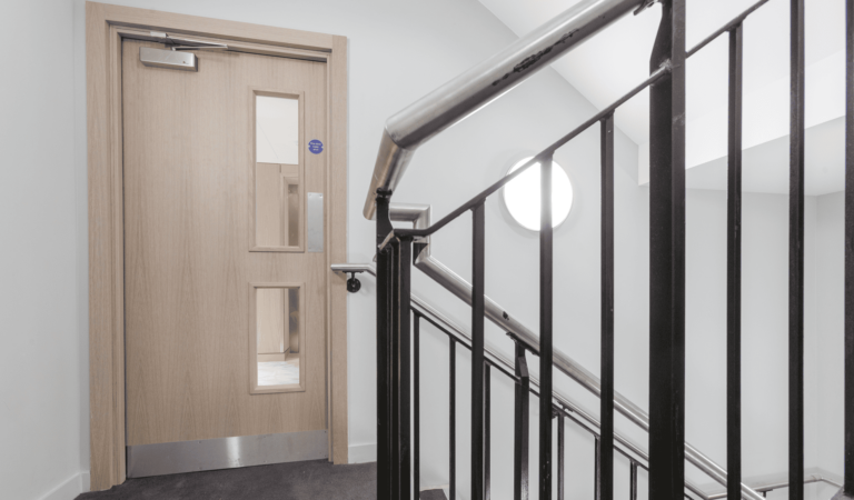 A metal handrail in front of a fire door