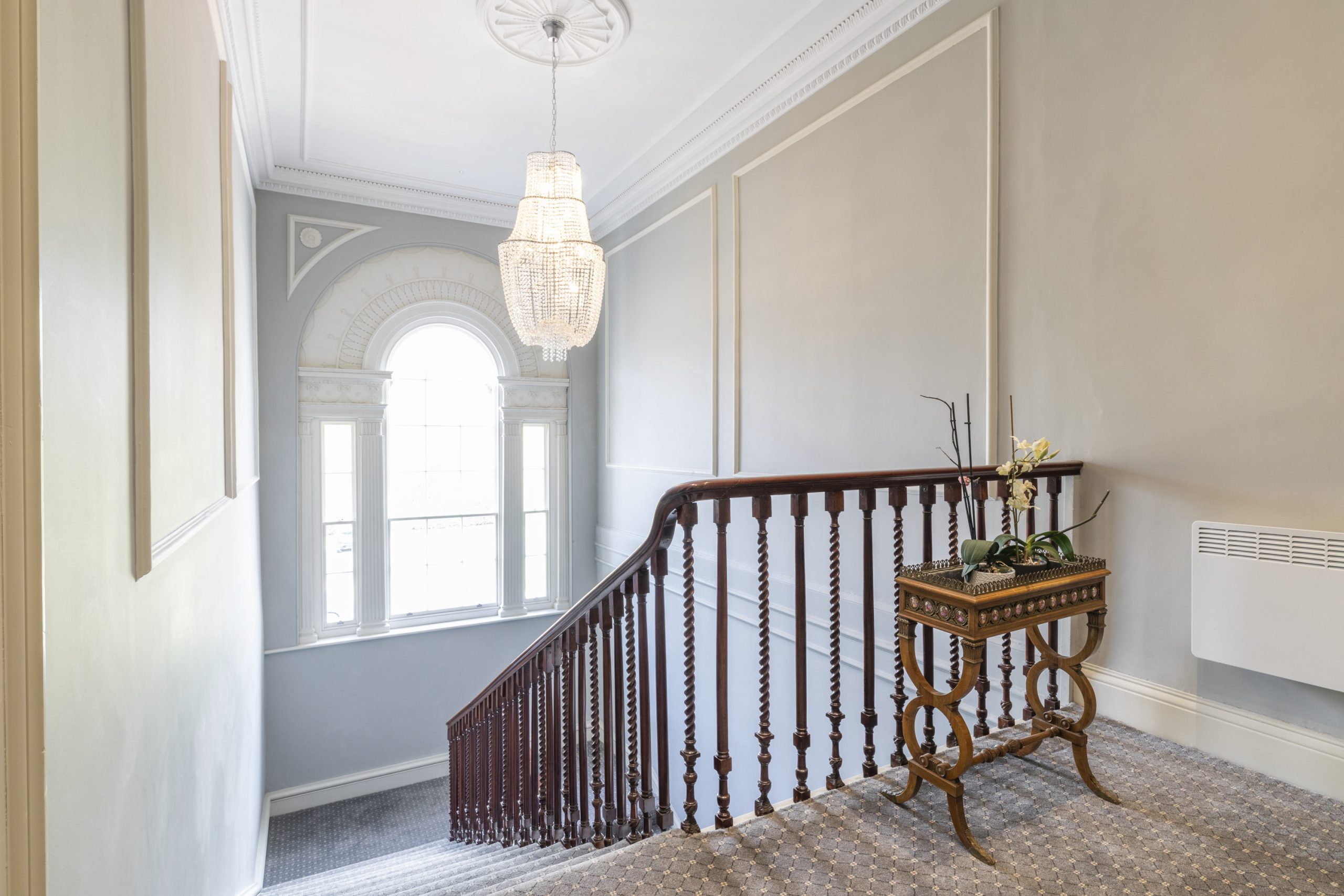 Grand staircase with a bespoke ornate sash window in Burley House