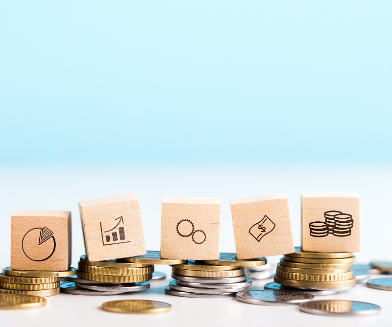 Image of business icons balancing on coins