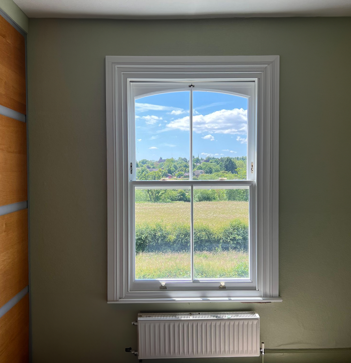 Sliding Sash window with a swept siteline with a view of Yorkshire countryside.